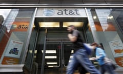 People pass an AT&T store along New York's Madison Avenue.