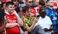 Arsenal fans check their phones in the stands at the Emirates