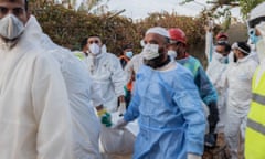 Rescue workers in masks and plastic protective clothing