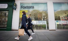 Two women walking past Foxtons estate agents in Angel, Islington