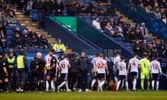 Players leave the pitch with the match called off due to a medical emergency in the crowd