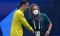 Australian swimming coach Dean Boxall (right) wears a mask as he shakes hands with Australian swimmer Flynn Southam.