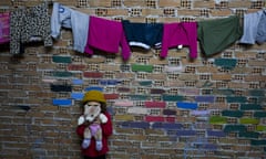 Afghan refugee Rukhsar Sameem, 4, covers her face with a teddy bear while playing at a refugee camp