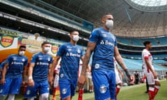 FBL-BRA-GREMIO-SAO LUIZ-CORONAVIRUS<br>Players of Gremio enter the field wearing protective face masks to prevent the spread of the new Coronavirus, before the match against Sao Luiz, at the closed-doors Arena do Gremio stadium, in Porto Alegre, Brazil, on March 15, 2020. (Photo by Richard DUCKER / AFP) (Photo by RICHARD DUCKER/AFP via Getty Images)