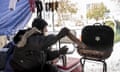 Tim tends a fire he used for heat and cooking at a homeless camp in Austin, Texas, on Tuesday Feb. 16, 2021, during an extreme cold snap. Temperatures dropped into the single digits as snow shut down air travel and grocery stores. (Jay Janner /Austin American-Statesman via AP)