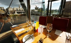 A set table next to a large window overlooking the river Ness