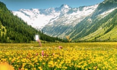 Digital illustration of hand holding mobile phone up out of a field of yellow flowers , with blue skies and mountains behind