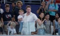 Tom Daley's husband Dustin Lance Black gestures to him while he holds their youngest son Phoenix and other son Robbie watches.