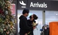 a masked couple greets each other at Perth airport arrivals gate