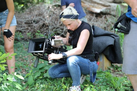 woman points camera while looking down at it