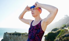 Older Caucasian woman putting on goggles on beach