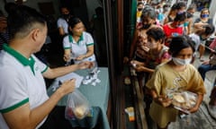 People queue for free food at a charity centre in the Philippines