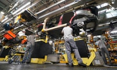 People working on a car on a production line in a factory