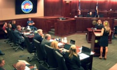 In an image made from video, James Holmes, far left, listens during a statement read by Kathleen Pourciau, far right, the mother of shooting survivor Bonnie Kate Pourciau-Zoghbi.