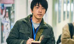 Actor Bai Ke holds a pen and notebook, looking up