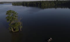 An angler casts his line while fishing from a small boat near a tree erected in the middle of Loch Raven Reservoir, Monday, June 29, 2020, in Glen Arm, Md. Temperature is expected to reach into the low 90s on Monday and will continue to rise heading into the Fourth of July holiday weekend. (AP Photo/Julio Cortez)