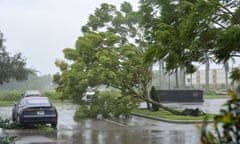 Gusts from Hurricane Ian begin to knock down small trees and palm fronds in a Florida hotel parking lot.