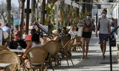 People take a drink or chill in a terrace bar at Playa de Palma beach in Palma de Mallorca, a day before it becomes mandatory to wear a protective mask on the beach as a measure against the spread of the coronavirus disease (COVID-19), Spain, March 30, 2021. REUTERS/Enrique Calvo