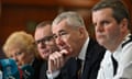 Jon Boutcher sits between colleagues at a press conference