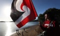 Devhante Marsters-Herewini holds a flag on the Waitangi bridge  in Waitangi, New Zealand