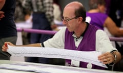 A polling official checks a ballot paper from the WA Senate rerun at an counting centre at Belmont, Perth, on 10 April 2014.