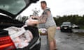 A man loads up sandbags to his car at Pimpama on the Gold Coast, Sunday, December 13, 2020. Heavy rainfall, high winds and flooding is forecasted for the region and into northern NSW. (AAP Image/Dan Peled) NO ARCHIVING