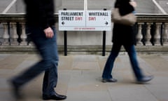 Blurred pedestrians pass the street sign on a Westminster pavement, where Parliament Street becomes Whitehall.