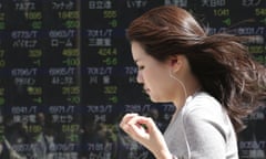 A woman walks by an electronic stock board of a securities firm in Tokyo, Friday, April 15, 2016. Asian stocks mostly edged lower on Friday as investors assessed a report on Chinese quarterly economic growth while Japanese shares dropped after an earthquake. Market players were also watching for cues on currencies and other policies from a meeting in Washington, D.C., of financial ministers and central bank governors of the Group of 20 leading industrial nations. (AP Photo/Koji Sasahara)