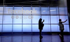 Attendees take selfies in front of a sign at Facebook’s F8 conference in San Jose, California, in April 2019. 