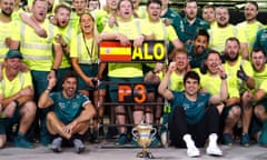 Aston Martin's Fernando Alonso celebrates with the trophy and team after finishing third in the Bahrain Grand Prix.