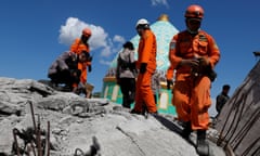 Rescuers and policemen walk on top of a collapsed mosque as they try to find survivors after an earthquake hit on Sunday in Pemenang, Lombok Island, Indonesia, August 7, 2018. REUTERS/Beawiharta