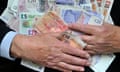 A man clutches a mass of banknotes