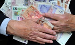 Man clutching piles of  paper money