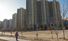 A woman walks next to an Evergrande housing complex in Beijing, China.