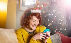 Woman looking at phone, laughing, at Christmas