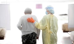 A nurse supports a patient as they walk in the Covid-19 alternative care site, built into a parking garage, at Renown Regional Medical Center, December 16, 2020 in Reno, Nevada.