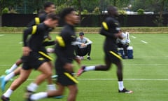 Chelsea’s manager Thomas Tuchel sits on a ball as his players go through their paces.