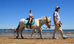 A girl enjoys a donkey ride on Scarborough beach in North Yorkshire