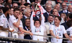 Crawley’s Liam Kelly lifts the League Two playoff trophy in the air at Wembley.