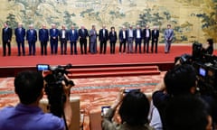 China's foreign minister, Wang Yi, poses with members of the Palestinian factions on a large red carpet