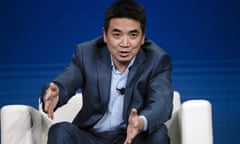 Eric Yuan gesturing while sitting on a white chair