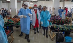 Zambian president Hakainde Hichilema in blue gown seen during a visit to the national cholera treatment centre surrounded by medical staff