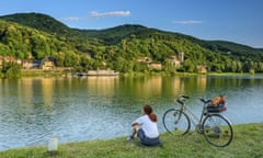 Woman cycling sitting at Danube, Danube arm at Altenberg, Altenberg, Danube Bike Trail, Lower Austria, Austria<br>W1MN3T Woman cycling sitting at Danube, Danube arm at Altenberg, Altenberg, Danube Bike Trail, Lower Austria, Austria