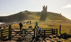 The view approaching the silhouetted ruins of Dunstanburgh Castle Pub Walk for travel the Jolly Fisherman, Craster, Nortumberland