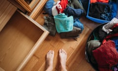 Someone's feet surrounded by piles of clothes