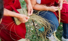 Craftswoman teaching coworker weaving with esparto grass