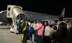 People queue outside to board a plane.