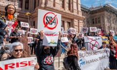 People hold up signs with a red slash over 'SB4'