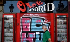 a man walks past a closed bar in Madrid