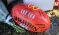 A miniature football sits among the floral tributes to victims of the Hunter Valley bus crash at the Singleton Roosters AFL home ground